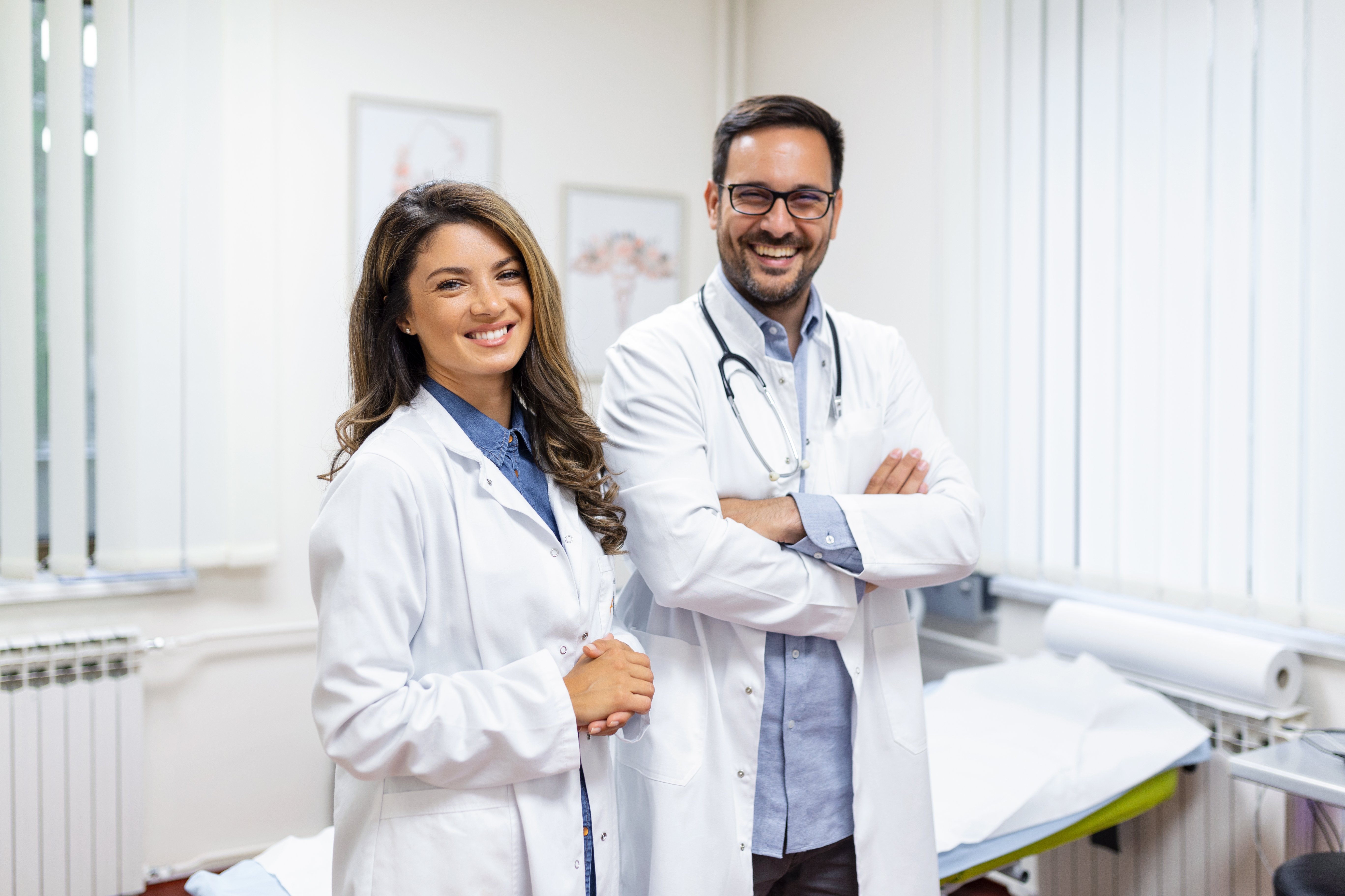 retrato-sonriente-joven-medicos-posicion-juntos-retrato-personal-medico-dentro-moderno-hospital-sonriente-camara